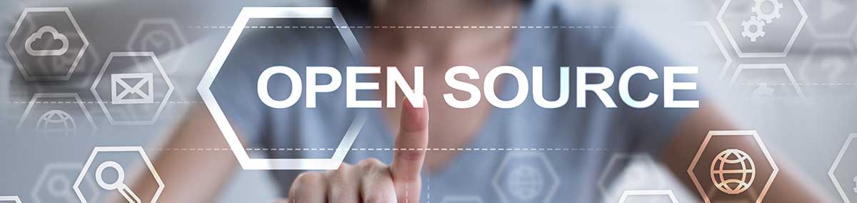 Person tippt auf ein Tablet vor transparenten Icons zu ‚Open Source’ und vernetzten Technologien.